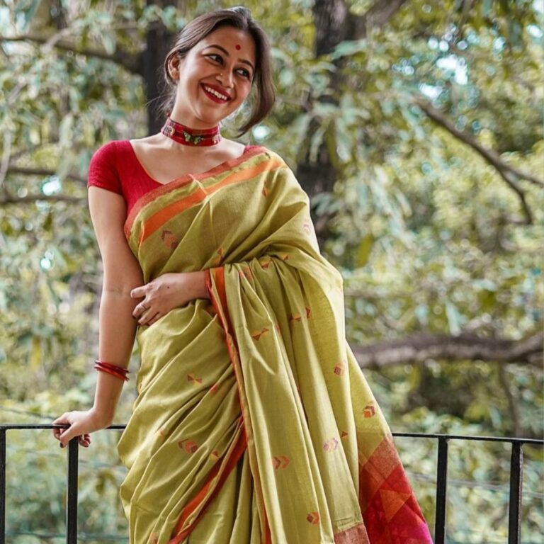 Photo of A south indian bride in a red saree poses for her bridal portrait.